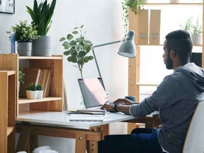 A man is sitting on a computer at home